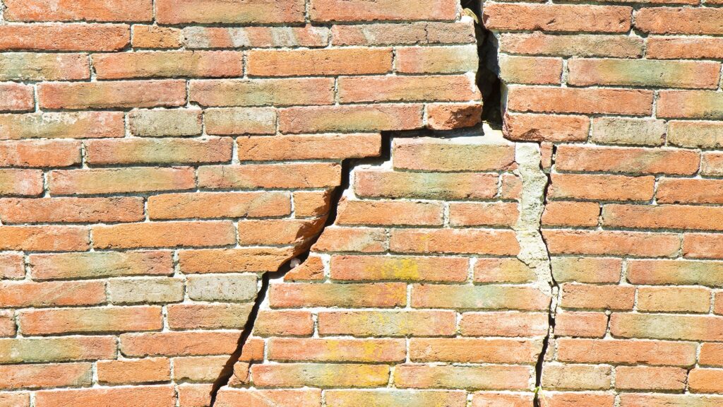 Brick foundation featuring deep cracks