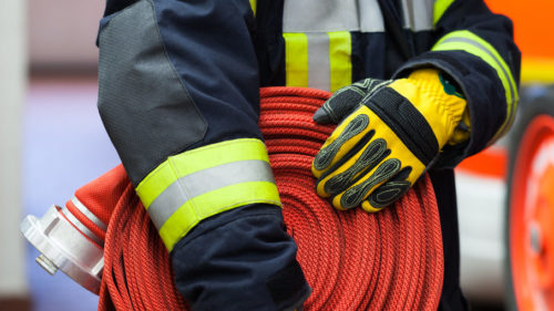 Firefighter with roller fire hose